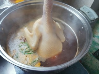 咸香鸡,然后用手攥着鸡头，把鸡放进锅里，再拿出来