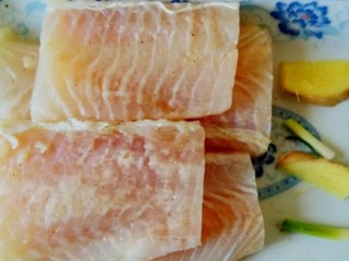 油泼鱼,将少许葱、姜垫在腌好的鱼肉下面