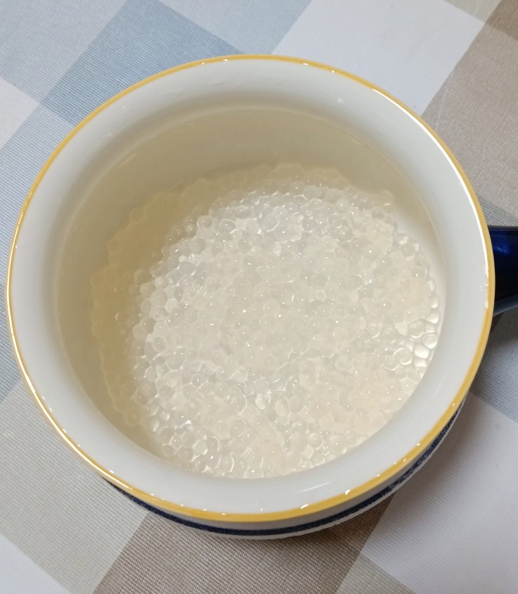 牛奶蜜豆西米露,西米沥干水分后倒入碗中