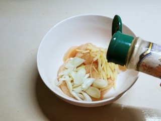 咸香鸡,葱切片，姜切丝和肉条一同放入大碗里，加入胡椒粉去腥增香。