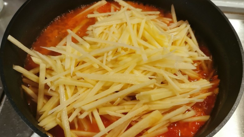 西红柿炒土豆丝,西红柿软烂后放入土豆丝翻炒。