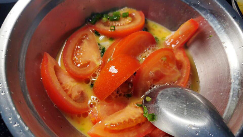西红柿炒土豆丝,将西红柿与葱花加入蛋液中