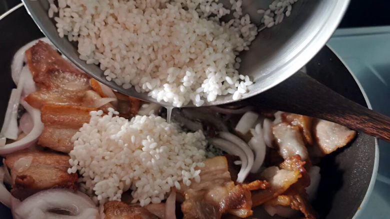 五花肉焖饭,大米加入锅中