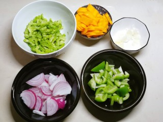 杂炒蔬菜,葱切片、蒜切碎、苦瓜和胡萝卜切片、青椒切块、洋葱切丝。