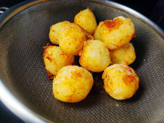 土豆香菇焖鸡,表面金黄即可捞出控油。成品盘中，先装入鸡块，旁边放炸土豆球