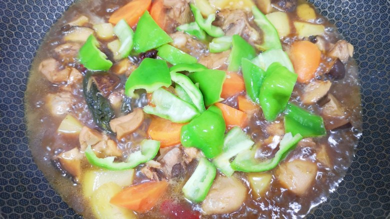 土豆香菇焖鸡,下入青椒块翻炒至断生。