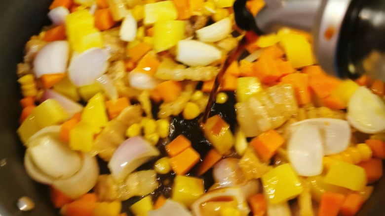 五花肉焖饭,放入玉米粒和洋葱翻炒，倒入酱油提味。