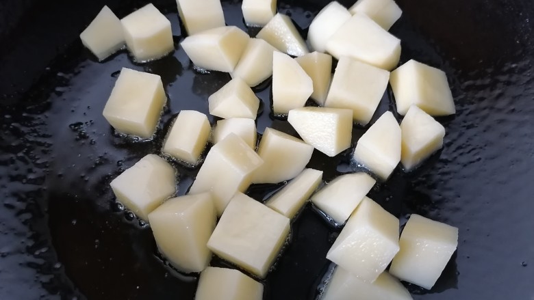 土豆香菇焖鸡,锅内放油烧热放入土豆
