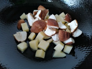 土豆香菇焖鸡,放入香菇一同翻炒