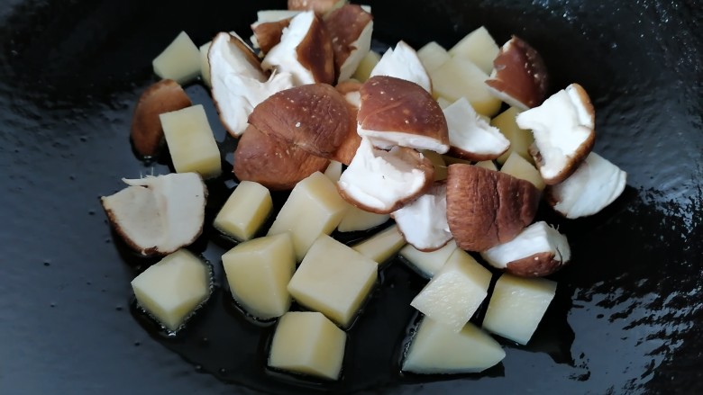 土豆香菇焖鸡,放入香菇一同翻炒