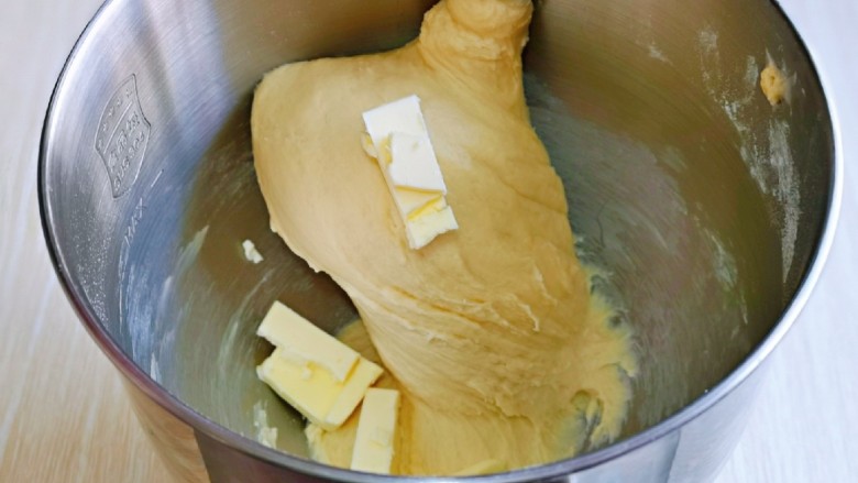 肉松牛角包,这时面团处于扩展阶段，加入室温软化的黄油，再次揉面一个程序。