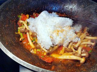 番茄海鲜饭,米饭倒入锅中，轻轻压一下，让酱汁包住米饭