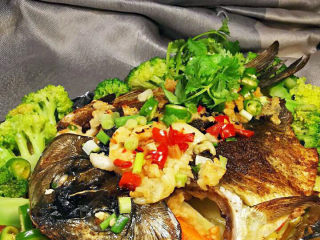 香烤鲫鱼,烤好的鲫鱼取出后，用西兰花围边，撒上香菜与小米椒。