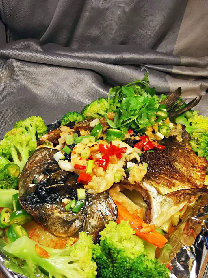 香烤鲫鱼,烤好的鲫鱼取出后，用西兰花围边，撒上香菜与小米椒。