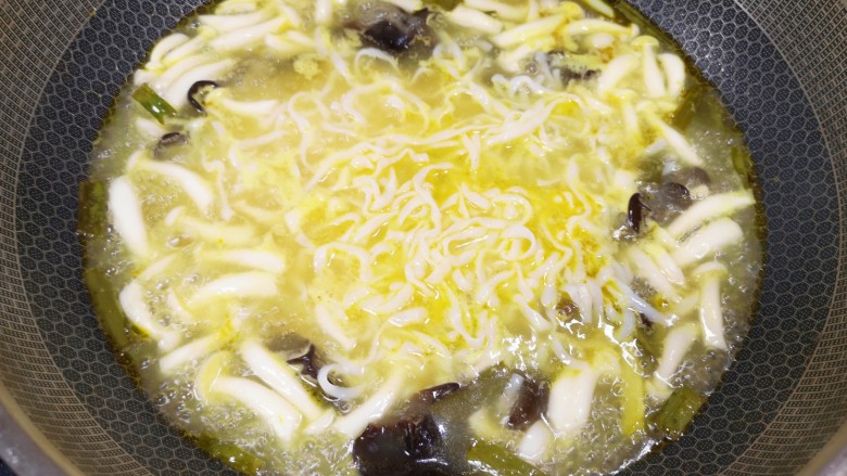 酸汤肉片,下入白玉菇和木耳煮开，再下入魔芋粉煮2分钟。