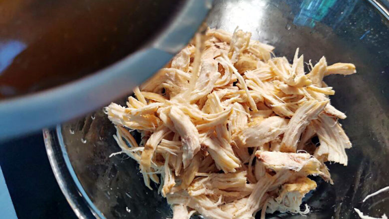 凉拌麻辣鸡丝,鸡肉丝里加少许浸泡的鸡汤汁，目地是让鸡肉撕开的表面吃进汤汁，不干柴