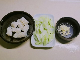 黄瓜炒鱿鱼,鱿鱼花放入开水中快速汆烫捞出，黄瓜切片，蒜切碎备用。