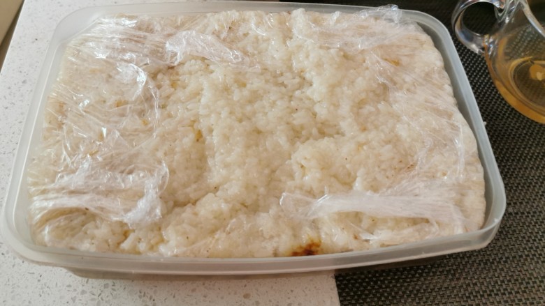 红枣切糕,最后再铺一层糯米饭，覆盖保鲜膜，压上重物静置。