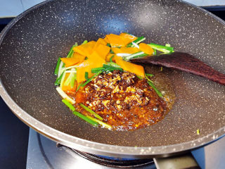 黄瓜炒鱿鱼,锅中加油爆香葱段与胡萝卜片之后，加入综合调味料