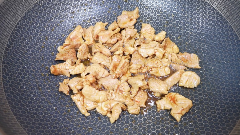 海带炒肉片,炒锅内倒适量的食用油烧热，下入腌好的肉片翻炒至变色。