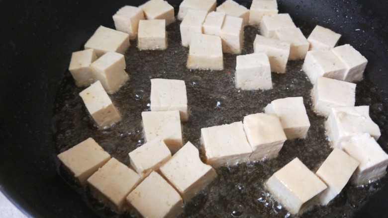 煎酿豆腐,倒入豆腐煎制。