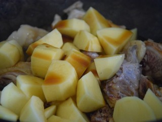 土豆焖鸡,加入土豆块，倒入酱汁，翻炒均匀