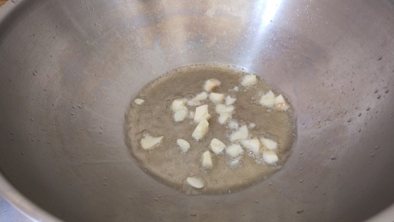 炝炒藕片,锅中倒入适量油烧热炒香大蒜。