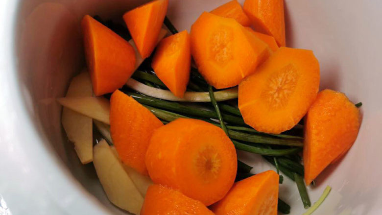 桃胶姬松茸炖鸽子,葱姜，胡萝卜放入炖盅里（铺上胡萝卜可以增加蔬菜甜味与营养，尤其是不爱吃胡萝卜的宝宝，炖在汤里喝)