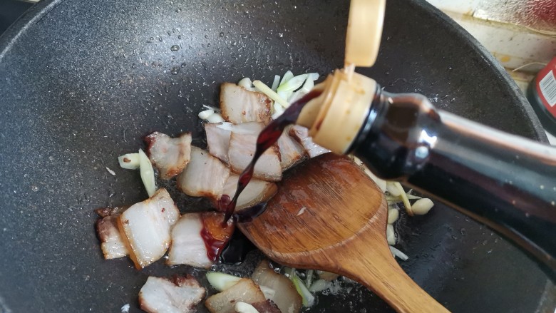 蒜苔五花肉,加入一勺酱油翻炒均匀