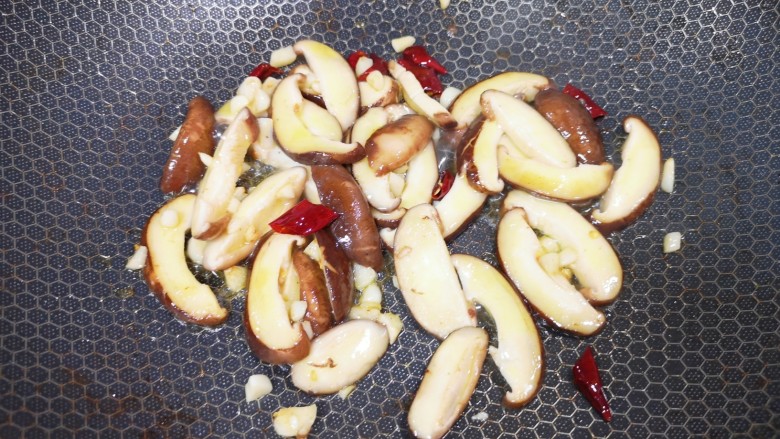 香菇炒生菜,下入香菇翻炒至变软。