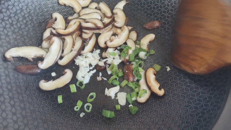 香菇炒生菜,下入蒜末和葱花炒香