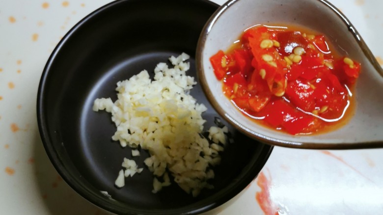 凉拌丝瓜,蒜切碎放入碗中，加入剁辣椒。