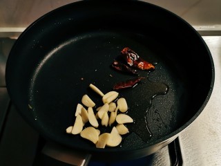 干煸圆白菜,起油锅放入食用油，油热后放入干辣椒和蒜片炒出香味。