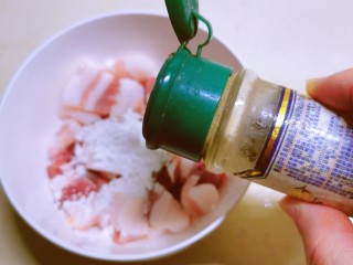蒜苔五花肉,肉片放入碗中，加入淀粉、胡椒粉和1汤匙酱油。