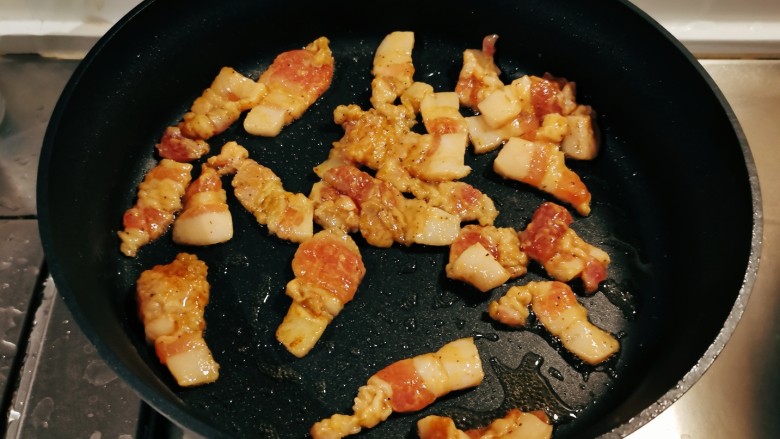 蒜苔五花肉,锅中再加入1汤匙食用油继续加热，放入五花肉片翻炒变色。