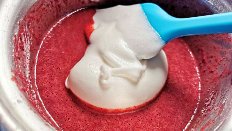 红曲蛋糕卷,挖一大勺蛋白霜到蛋液中，拌匀后再重复一遍