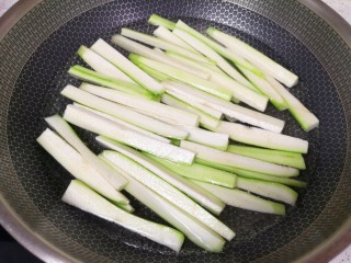 凉拌丝瓜,锅里放水烧开，下入丝瓜条，加入几滴食用油和少许盐，焯水两分钟。