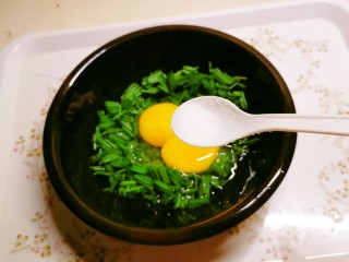 葱花炒鸡蛋,放入碗中，敲入鸡蛋，加入盐和胡椒粉。