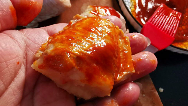 网红土豆酿鸡翅,将辣椒酱均匀涂抹在鸡翅兩面