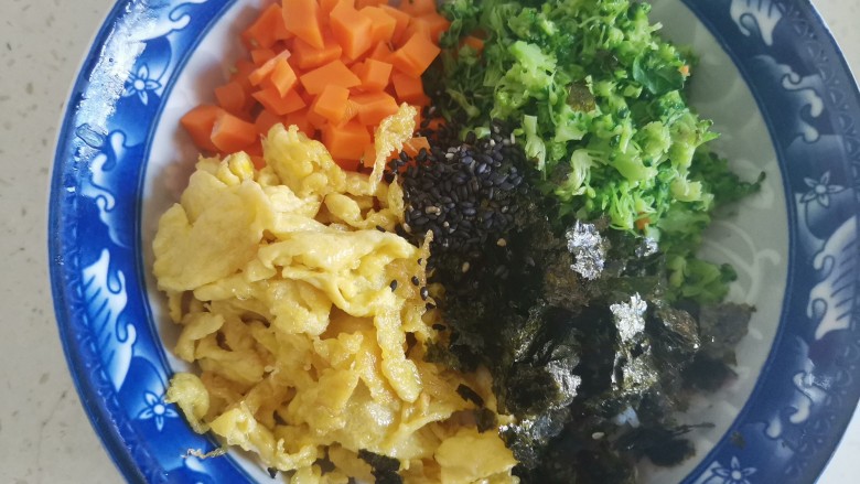 海苔拌饭,把西兰花切碎，加入米饭里，加入胡萝卜丁，鸡蛋碎，海苔碎和黑芝麻