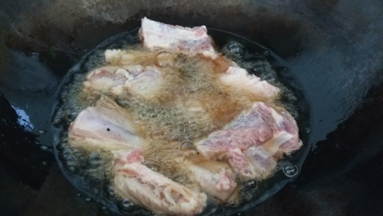 照烧排骨,锅中倒入适量油炸制排骨。