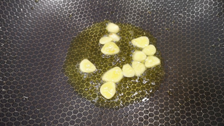 火腿青菜炒鸡蛋,锅里继续倒油烧热，下入蒜片炒香。