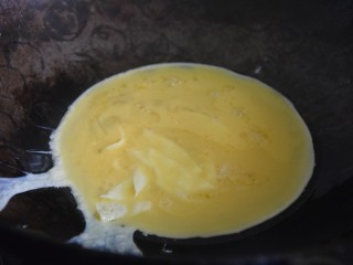 火腿青菜炒鸡蛋,热锅凉油，倒入蛋液煎至凝结，用锅铲切成小块