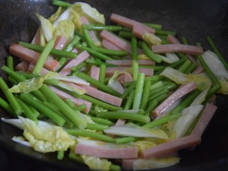 火腿青菜炒鸡蛋,起锅热油，倒入青菜和火腿中火翻炒三分钟左右