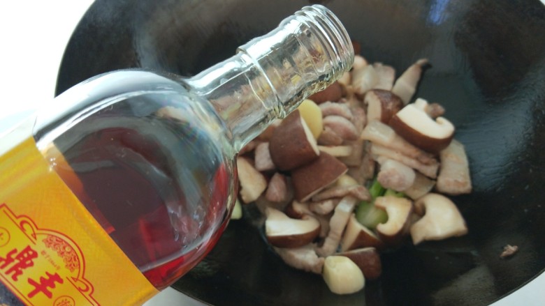 香菇肉片煲,倒入料酒。