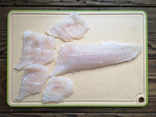 金汤鱼,将鱼柳斜刀片成鱼片。