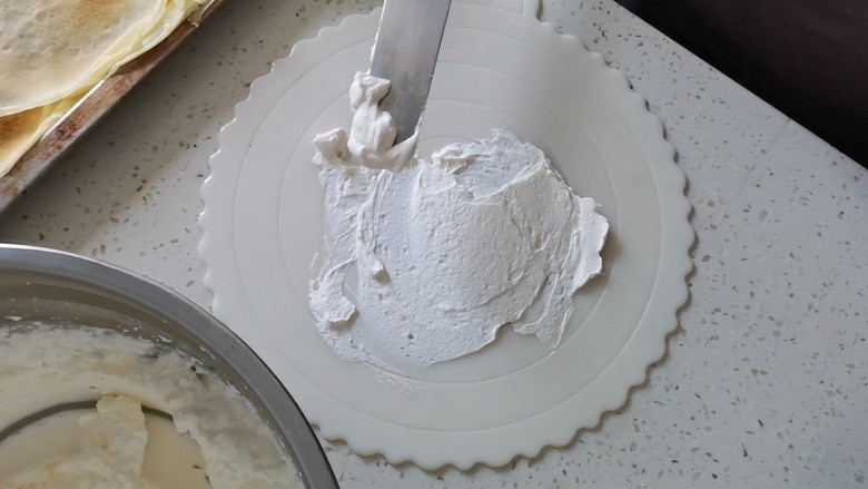 芒果千层蛋糕（薄饼机版）,然后把蛋糕盘底部抹上一层薄薄的奶油