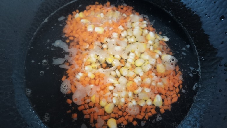 土豆泥蛋卷,锅里水烧开加入少许盐几滴油，放入玉米，胡萝卜粒焯水一分钟