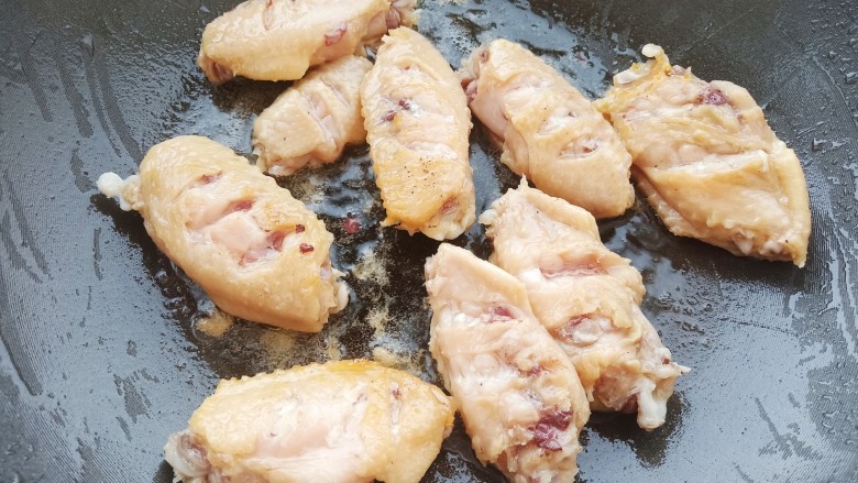 雪碧鸡翅,锅中烧油，加入鸡翅煎至表面微黄。