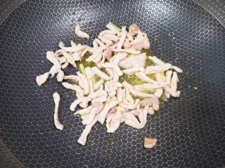蒜苔香干,炒锅内倒适量的菜籽油，下入姜丝和肉丝一起滑炒至肉丝变色。
